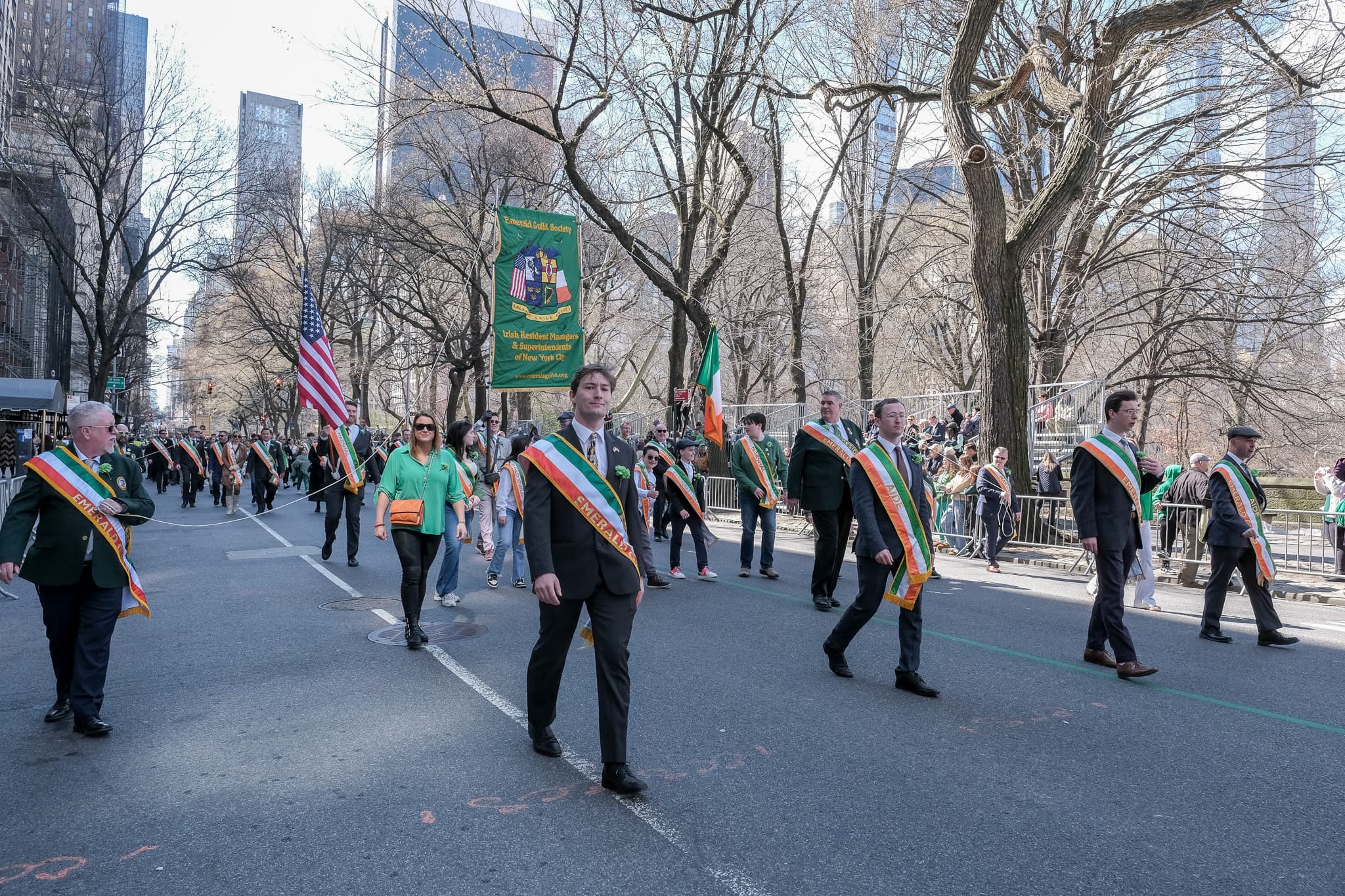 2024 Emerald Guild Society members marching behind the Guild banner during the St. Patrick's Day Parade.