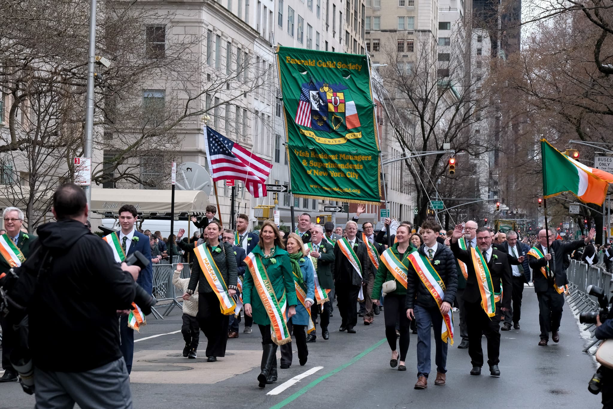 Emerald Guild Society members and banner advancing together during the 2025 St. Patrick's Day Parade.